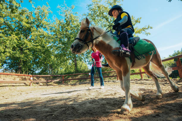 istock Personal trainer in horseback riding school for kids 857896518