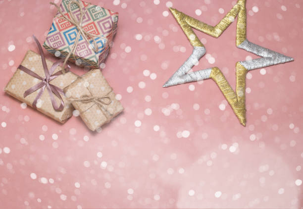 istock Christmas gift boxes. Christmas presents and star at pink table. Flat lay with copy space.Christmas card in vanilla style 857896818