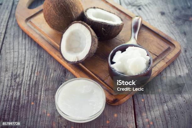 Coconut With Coconut Oil In Jar On Wooden Background Stock Photo - Download Image Now