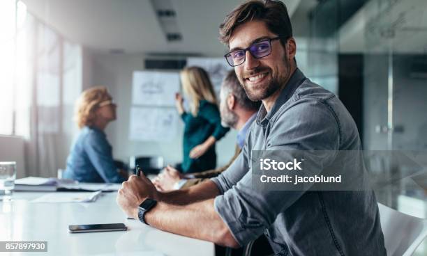Businessman Sitting In Board Room During Presentation Stock Photo - Download Image Now