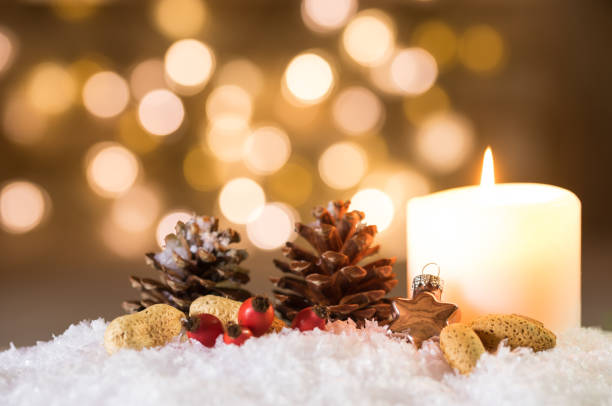 istock Advent Candle with decoration on snow with festive lights background 857908628