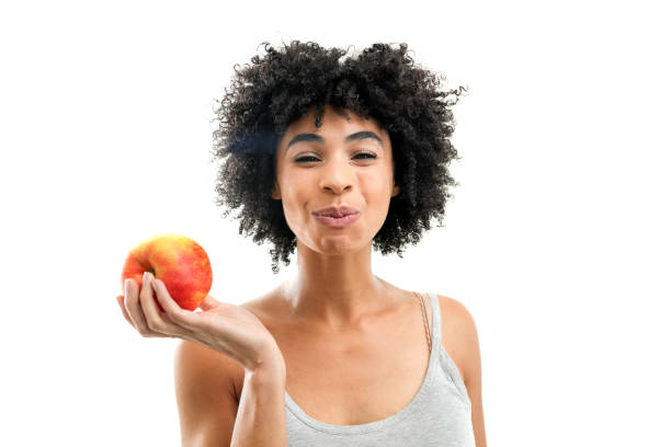 Woman eating an apple on white background