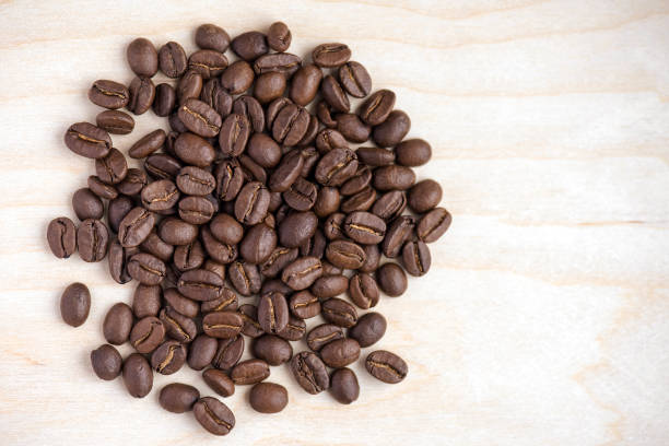 istock Brown coffee beans on the wooden table or surface with place for text or ideas 857916176