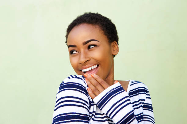 istock smiling young woman with hand over mouth 857924514