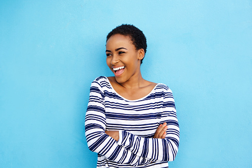 Cool mujer negra joven riendo contra pared azul photo