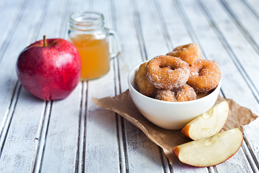 Sweet and savory apple cider donuts on a table.