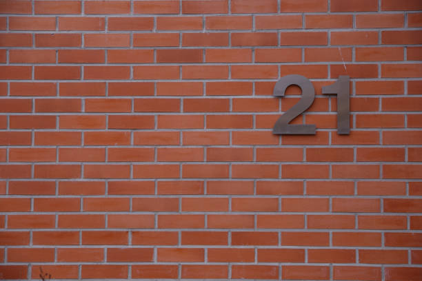istock House number 21 sign on  red wall 857931044