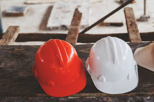 istock Helmet and blueprint on table on construction site, vintage tone 857931396