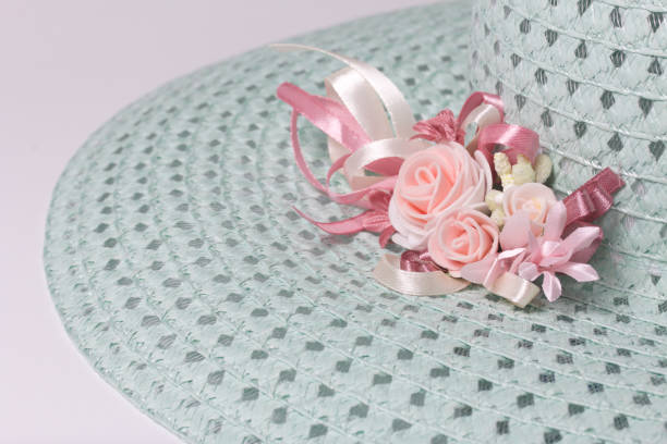 istock A broad-brimmed female hat is light green, with a buttonhole. Artificial flowers in the form of roses. 857932630