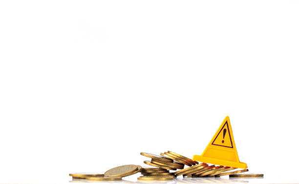 istock Financial risk. Coins falling and Warning label on whitebackground 857938604