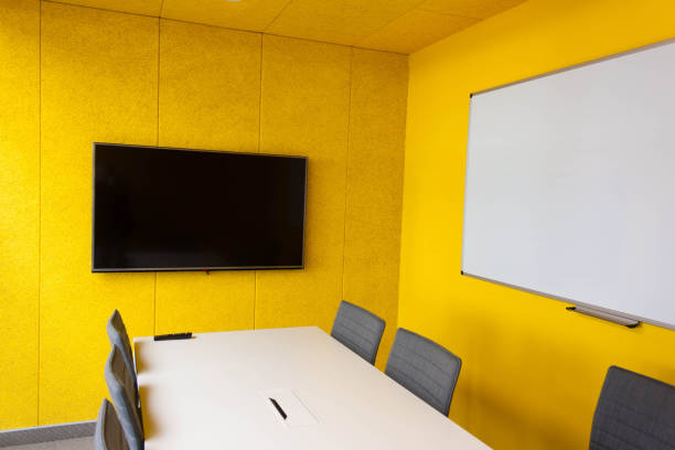 istock An empty office with yellow walls, a table, and gray chairs with 857939058