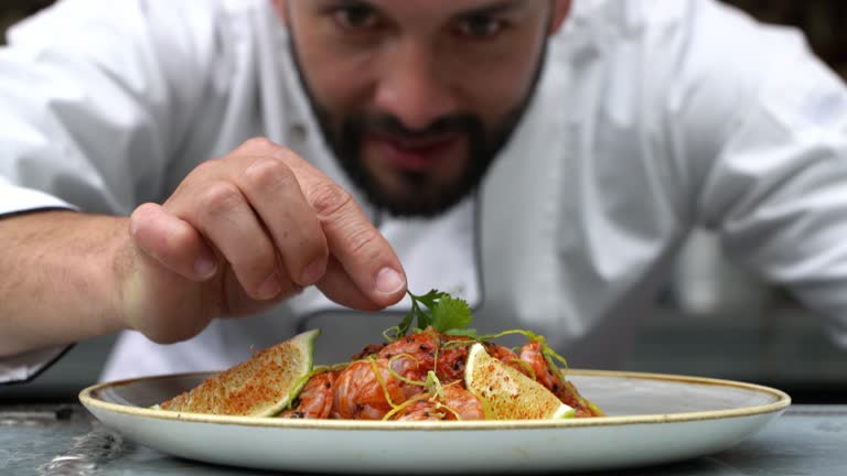 Zoom out of chef decorating his plate and looking very happy