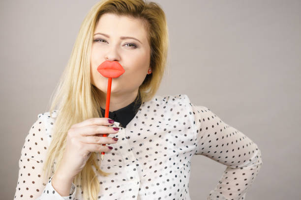 istock Happy woman holding fake lips on stick 857954928