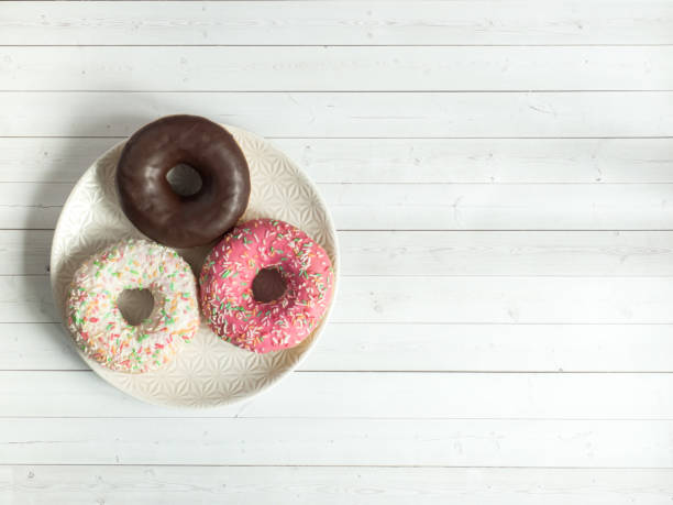 istock Colored donuts are on the plate coffee beans on wooden rustic background 857957814