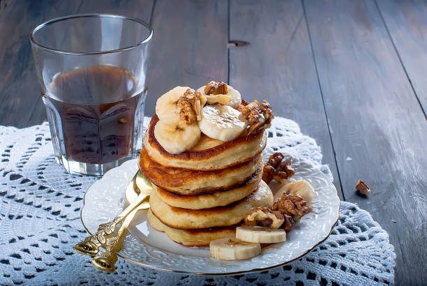 Pancakes with banana, nuts ,honey and cup coffee