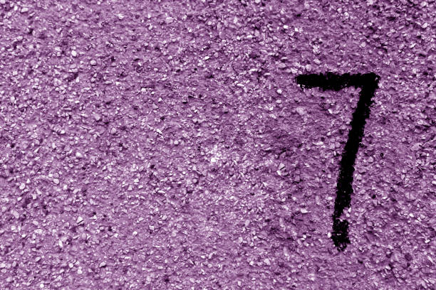 istock Number seven on purple grungy cement wall. 857958888