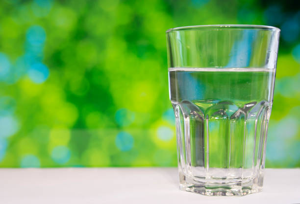 istock Faceted glass of water on nature background. 857965572