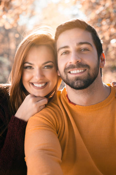 istock Young couple spending romantic time together in the public park, looking at camera. 857966282