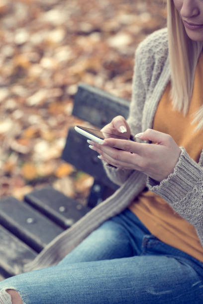 istock Close-up, women hands while Texting on phone in the Park 857969166