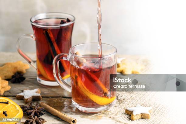 Mulled Wine In Glass Mugs With Christmas Cookies And Spices Like Orange Slices Cloves Star Anise And Cinnamon On A Bright Rustic Table Background Fades To White Copy Space Stock Photo - Download Image Now