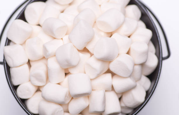 istock White mini puffy marshmallows ia a black bowl on white background with copy spase. Top view, close-up. 857970086