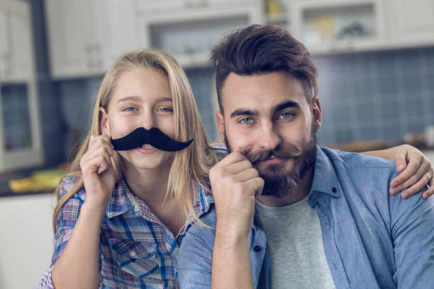 istock Mand and his daughter playing with moustache 857973180
