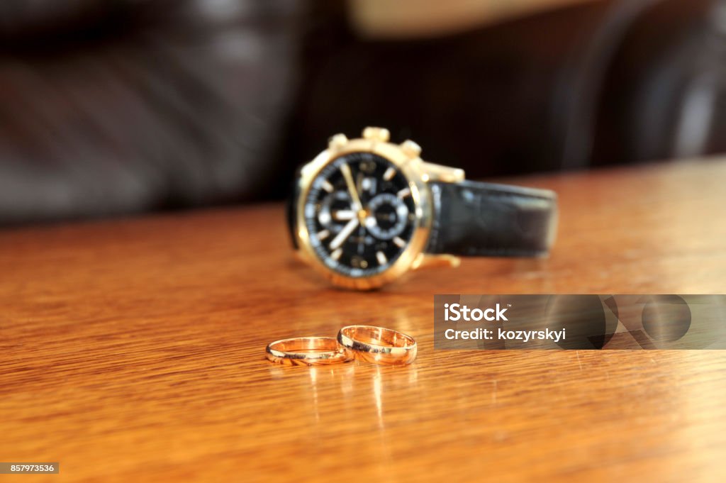 Ehering und Mann Uhren auf hölzernen Tisch - Lizenzfrei Accessoires Stock-Foto