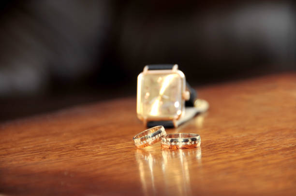 istock wedding ring and man watches on wooden the table 857973552