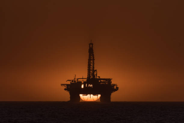 istock Sun setting behind oil drilling platform at Longbeach in Namibia 857976358