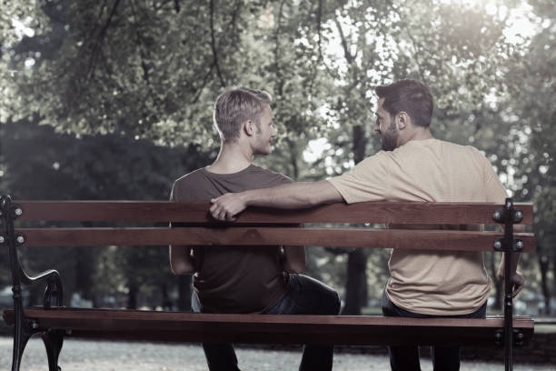 istock Friends sitting on a bench in the park 857978918
