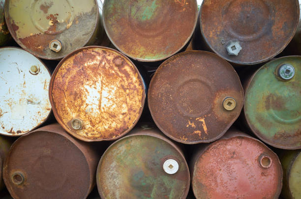 istock Rusty colors metal barrels stacked in rows 857981800