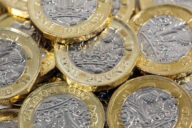 British Currency Scattered one pound coins one pound coin uk coin british currency stock pictures, royalty-free photos & images