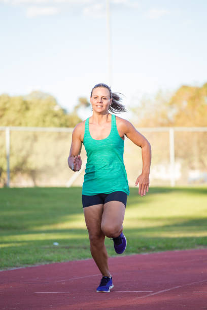 istock Female sprinter athlete on a tarmac athletics track. 857989064