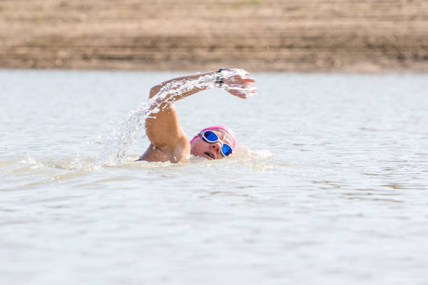 istock Female triathlete swimming in a dam. 857995828