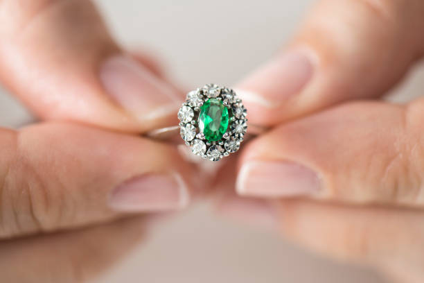 Woman holding a diamond ring Hands holding diamond. Emerald. emerald stock pictures, royalty-free photos & images