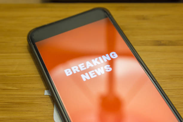 A cellphone displaying a big red breaking news alert encompassing the whole screen.