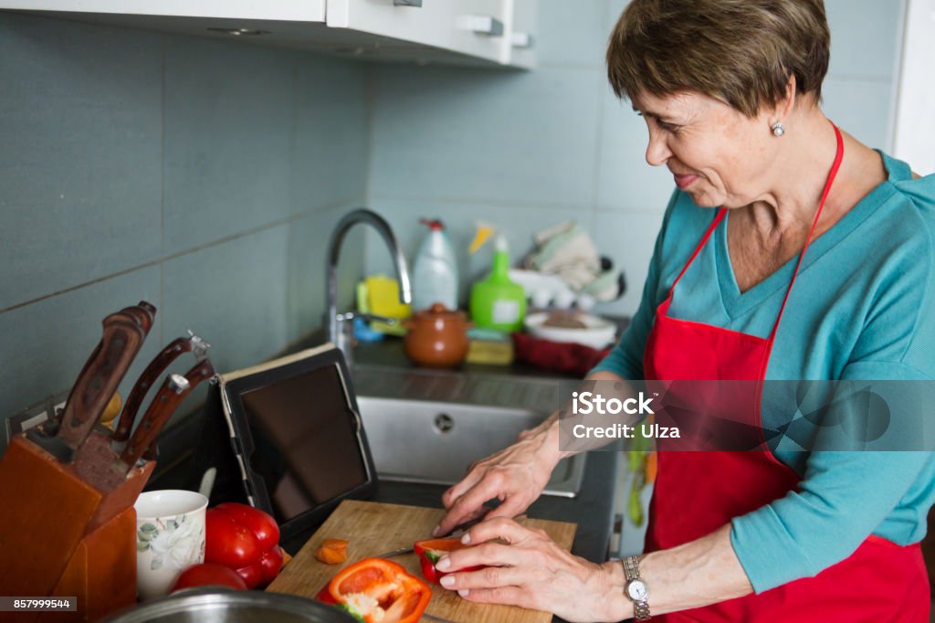 Happy elderly woman cooking  in kitchen at home Cooking Stock Photo