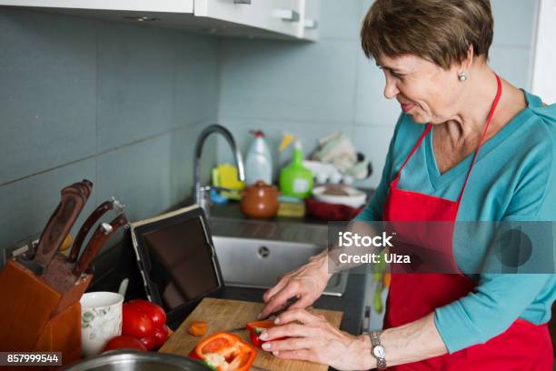 Happy Elderly Woman Cooking In Kitchen At Home Stock Photo - Download Image Now - Cooking, Senior Adult, One Person