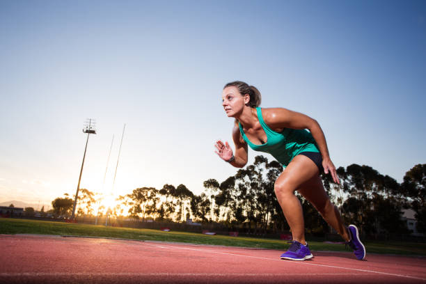 istock Female sprinter / athlete on a tarmac athletics track. 857999634