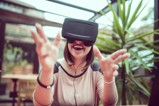 istock Young Woman Having Fun with Virtual Reality Simulator and Gesturing 857999950