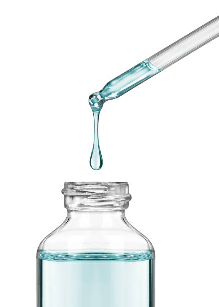 istock Drop falls from a pipette into a cosmetic bottle close-up on white background 858002868