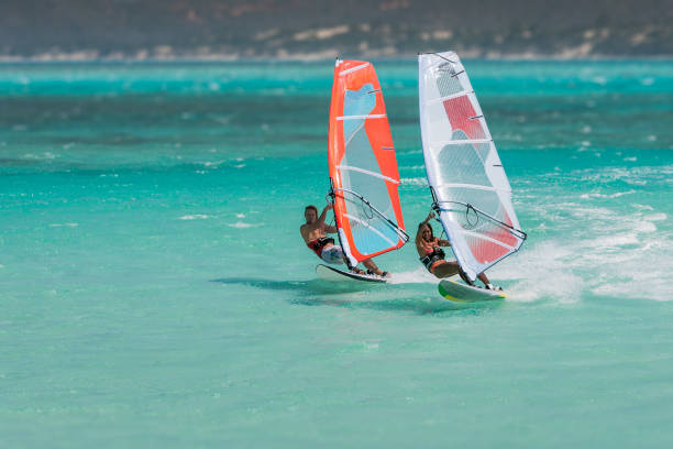 Couple windsurfers Couple windsurfers in the lagoon of Emerald Sea, Antsiranana bay (Diego Suarez), Madagascar. windsurfing stock pictures, royalty-free photos & images