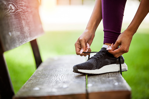 woman tying shoes outside, getting ready for a run