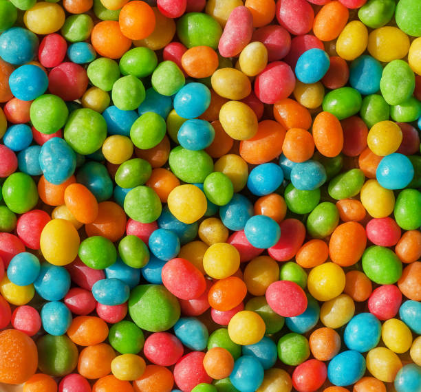 istock Colorful background of bright candy small round forms. Abstract sweets with raisins or nuts stuffing 858018200