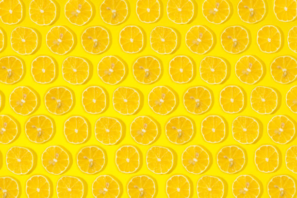 istock Slices of fresh lemons on yellow background. 858021364