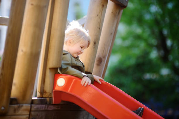 istock Happy little boy having fun on outdoor playground/on slide 858024208