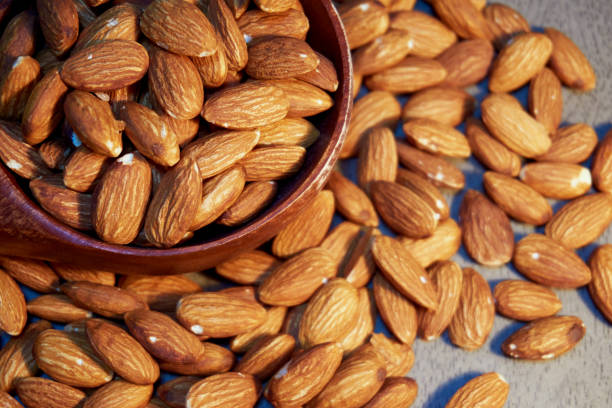 istock Round wooden bowl with almonds on the floor. 858024534