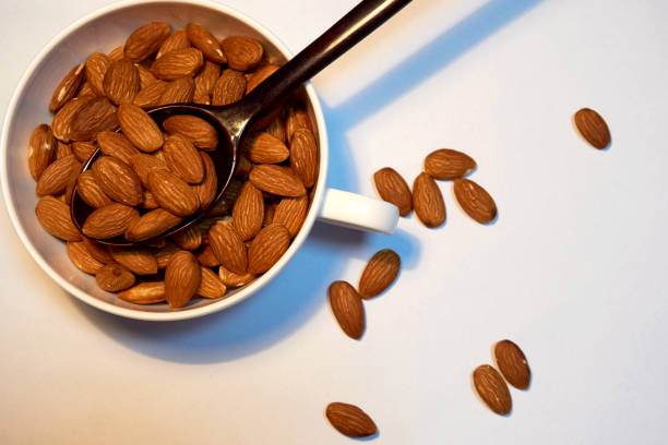 istock Almonds with white bowl and black wooden spoon. 858024594