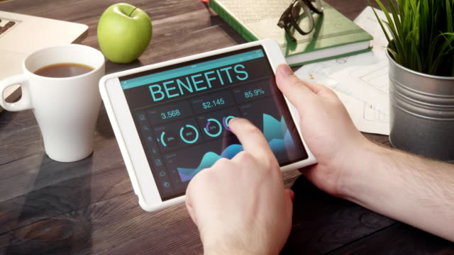 Checking benefits records using digital tablet at desk