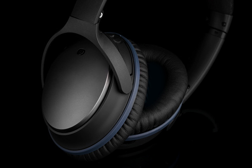 Black headphones on black background shown in high contrast